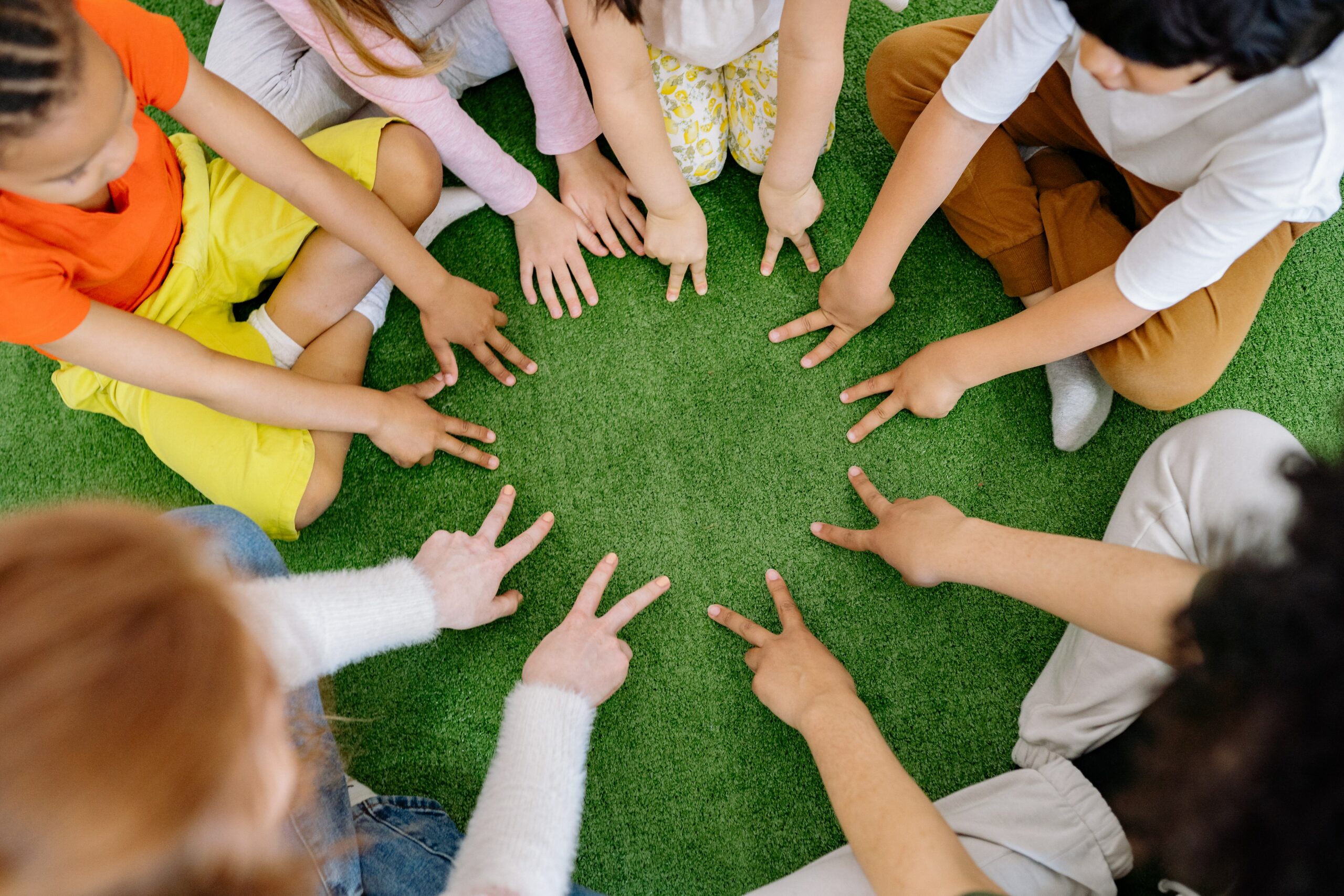 kids sitting in a circle, hands in the middle